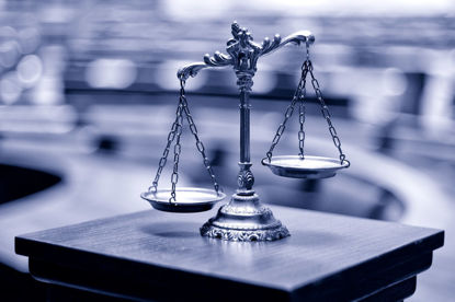 scale on pedestal in front of a blurred courtroom
